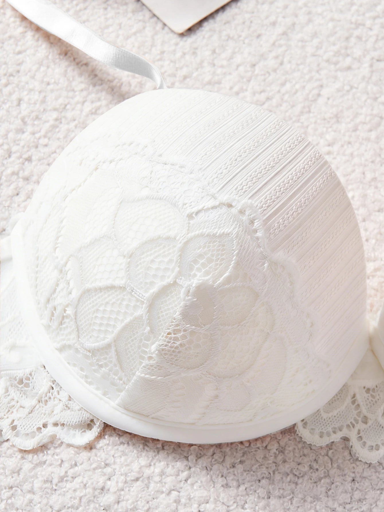 White lace bra on a textured surface