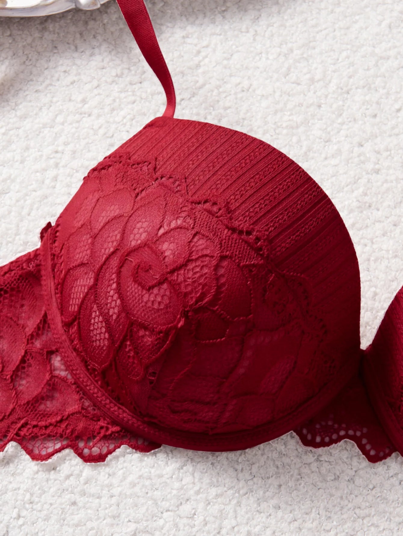 Red lace bra on a textured white background