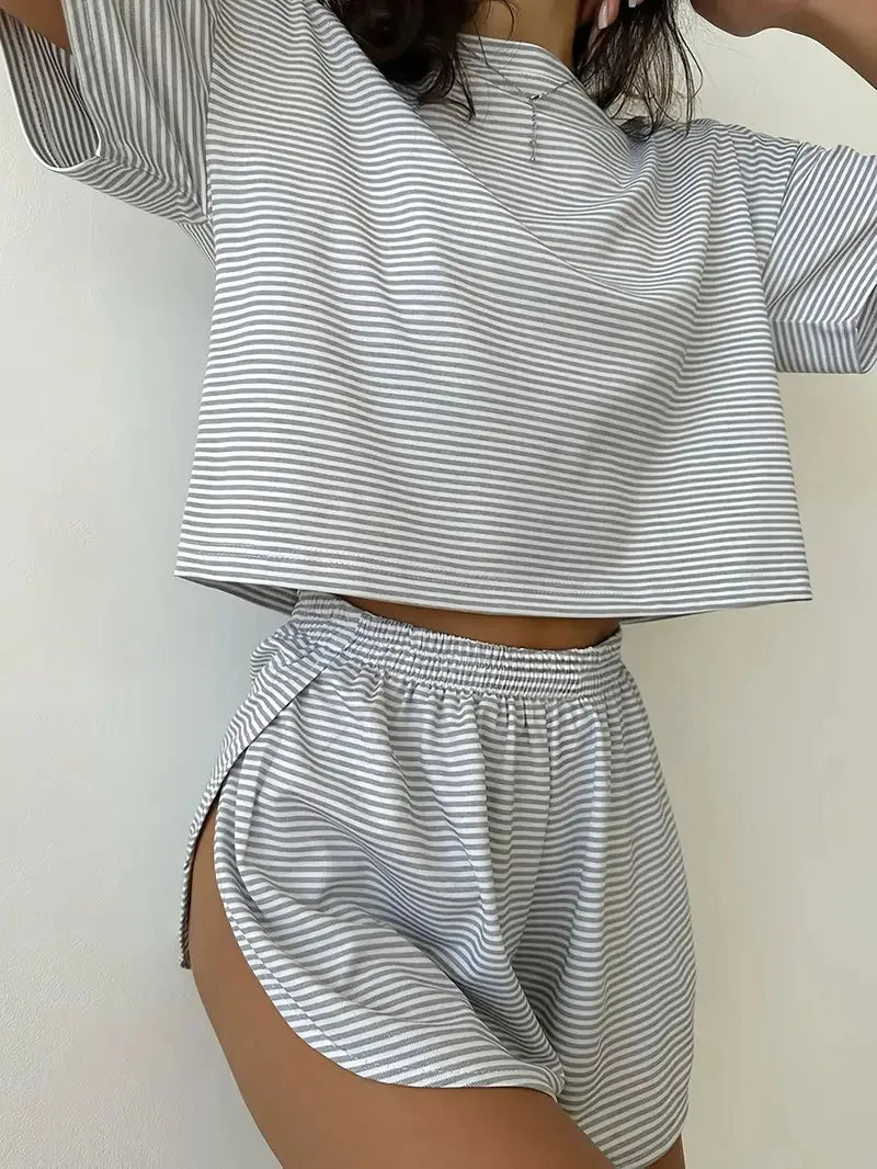 Person wearing a matching striped outfit with a crop top and shorts on a plain background