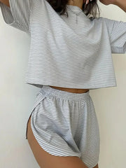 Person wearing a matching striped outfit with a crop top and shorts on a plain background