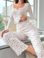 Woman wearing a floral pajama set sitting by a window with a cityscape view.