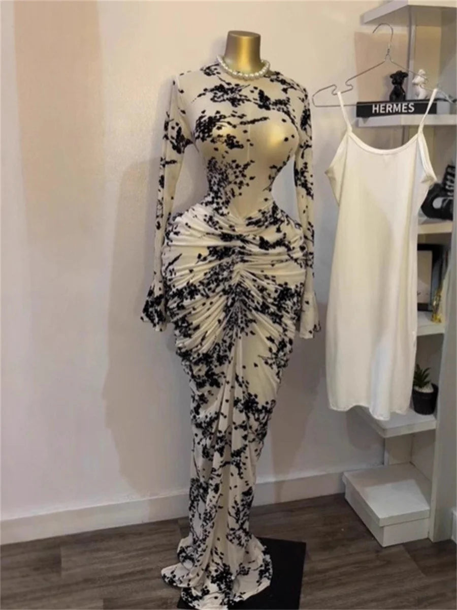 Black and white floral dress on a mannequin against a white wall with a Hermes sign in the background.