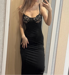 Woman taking a mirror selfie wearing a black dress with lace detailing.