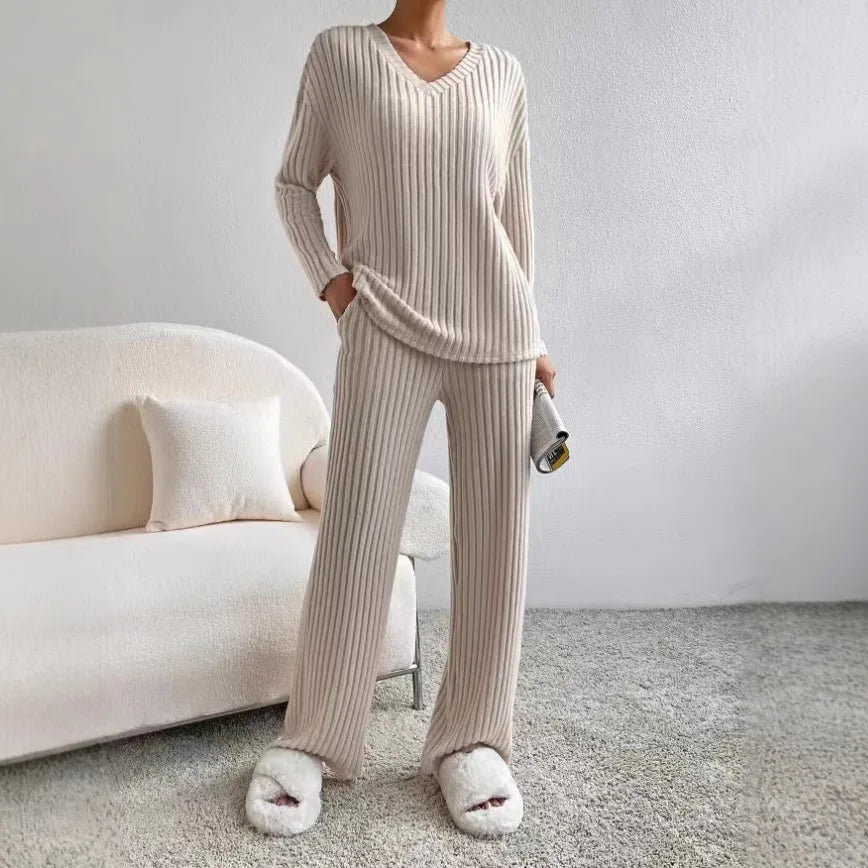 Person wearing a beige ribbed loungewear set in a minimalistic room.