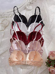 Set of three bras in black, red, and beige on a decorative background with flowers.