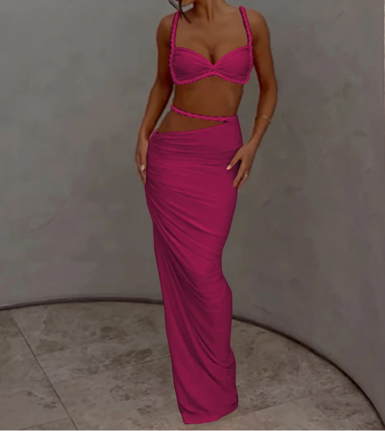 Woman wearing a bright pink two-piece outfit against a plain background