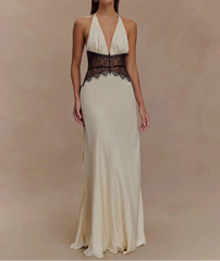 Woman wearing a long, elegant dress with a black lace bodice on a beige background