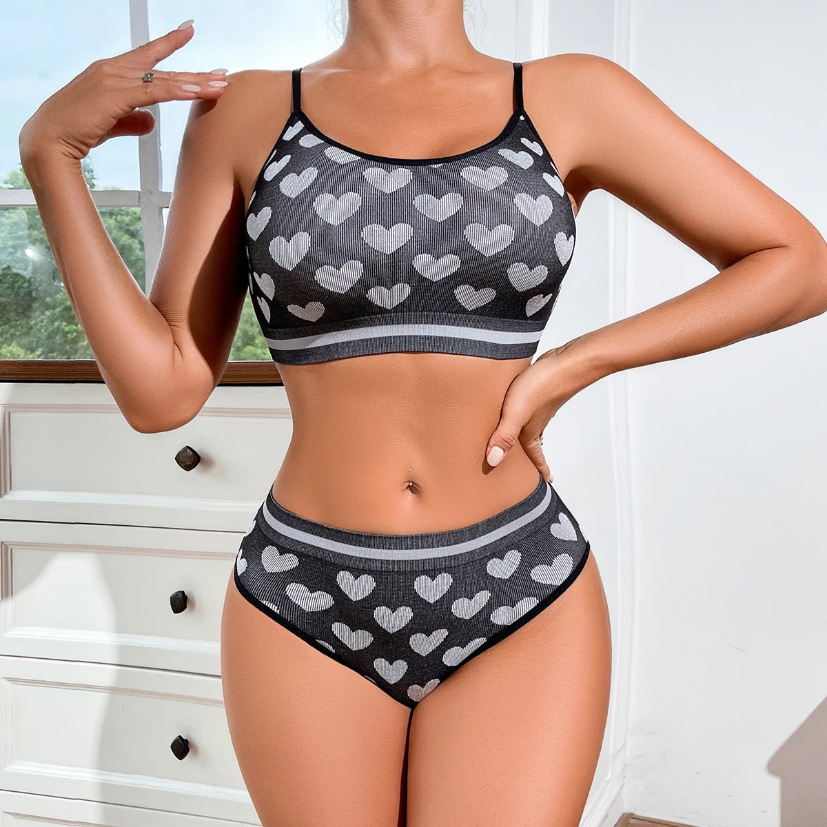 Person wearing a black and gray heart-patterned bikini set indoors.
