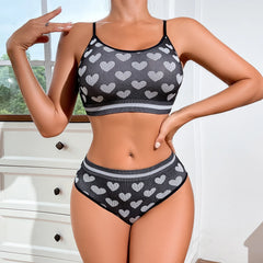 Person wearing a black and gray heart-patterned bikini set indoors.
