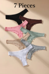 Set of six colorful lace-trimmed panties on a beige background