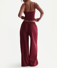 Person wearing a burgundy outfit with wide-leg pants on a white background