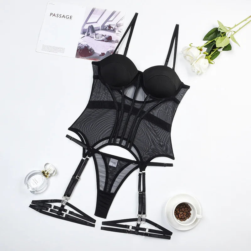 Black lingerie set with garters on a white surface with a magazine and flowers.