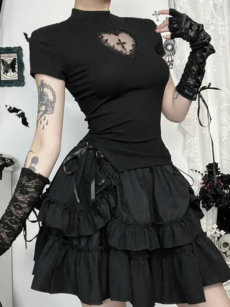 Person wearing a black gothic outfit with ruffled skirt and lace gloves.