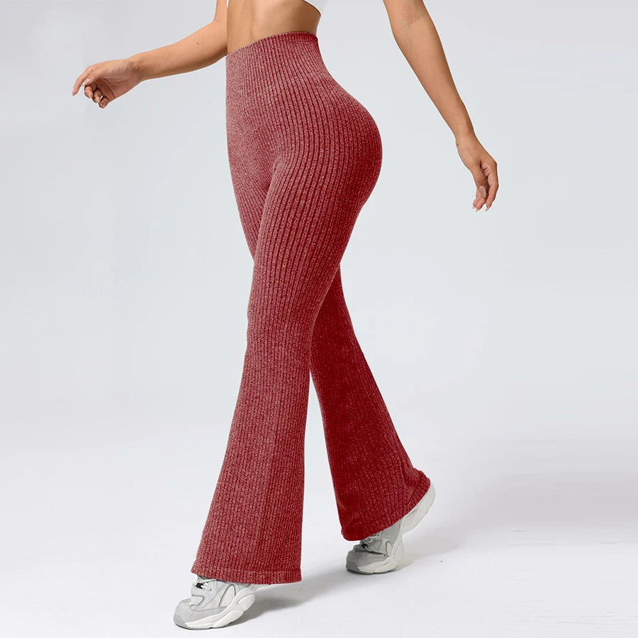 Person wearing red ribbed knit pants on a white background