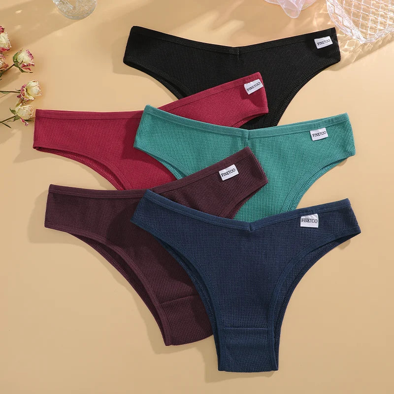 Four pairs of men's underwear in black, red, green, and blue on a beige background.
