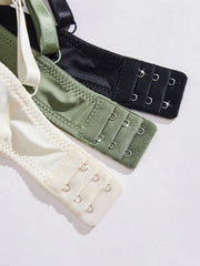 Three bra straps in black, green, and beige on a white background