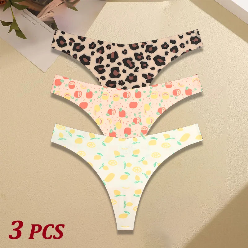 Three pairs of women's underwear with different patterns on a beige surface.