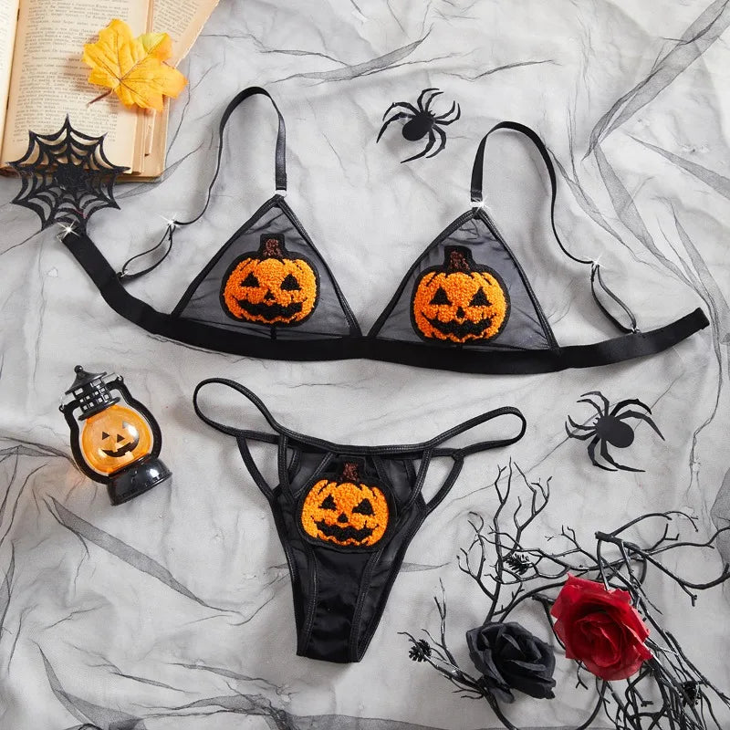 Halloween-themed lingerie set with jack-o'-lantern design on a spider web background.