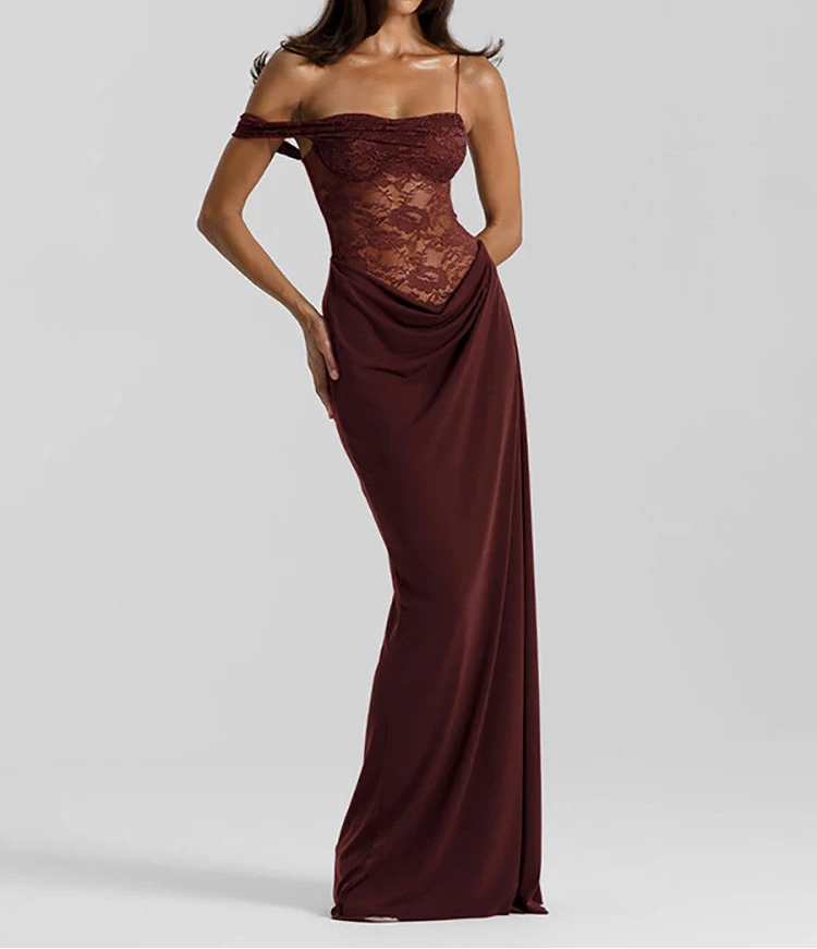 Woman wearing a burgundy evening gown with lace detailing on a light gray background