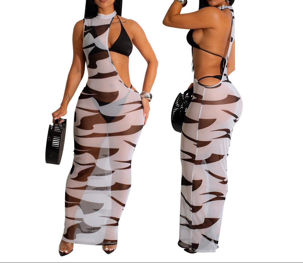 Woman wearing a camouflage jumpsuit with a black top, holding a black handbag.