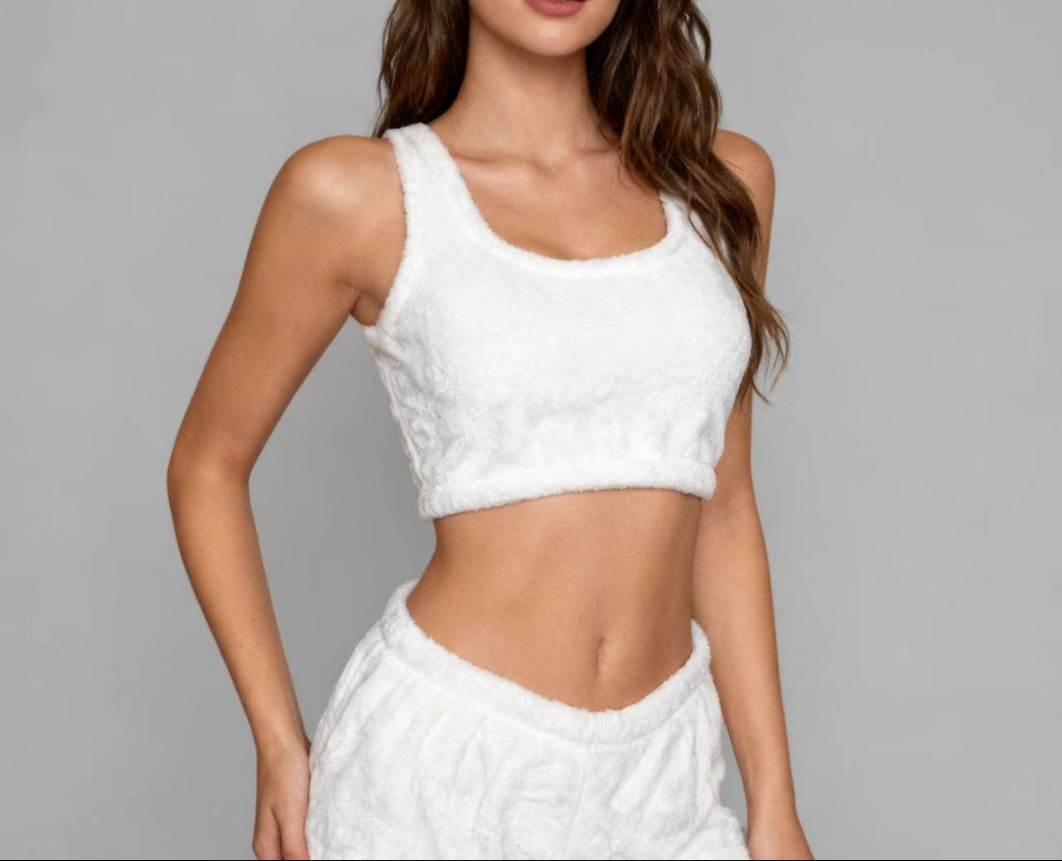 Woman wearing a white sleeveless top and skirt against a gray background