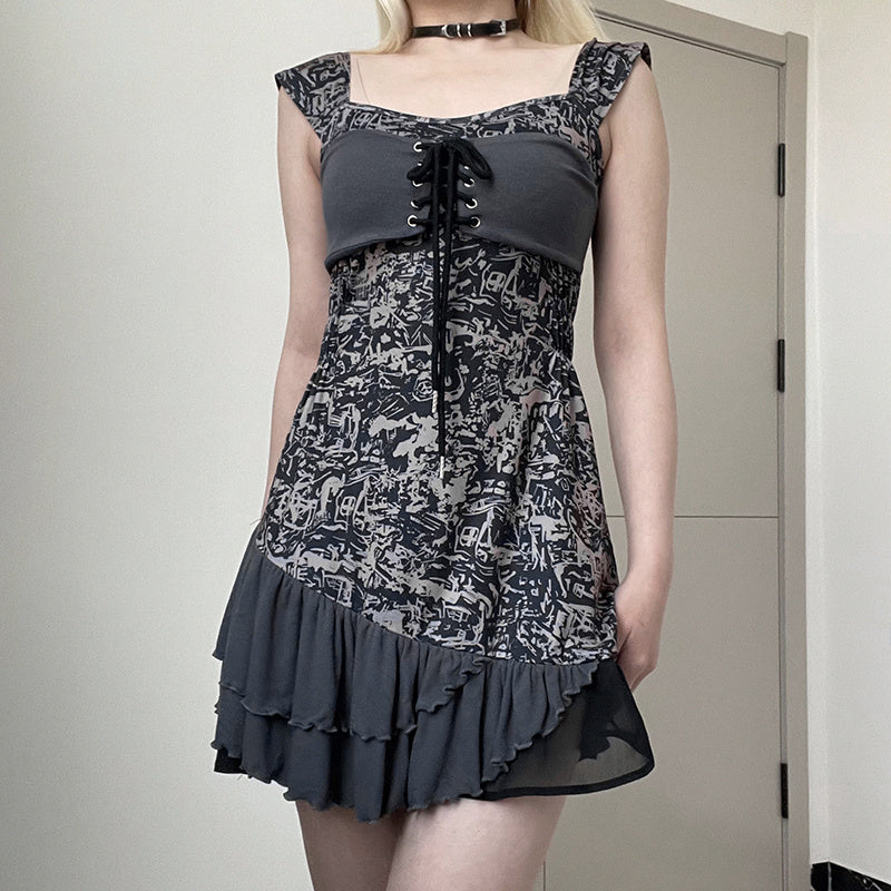 Person wearing a black and gray patterned dress with a plain background