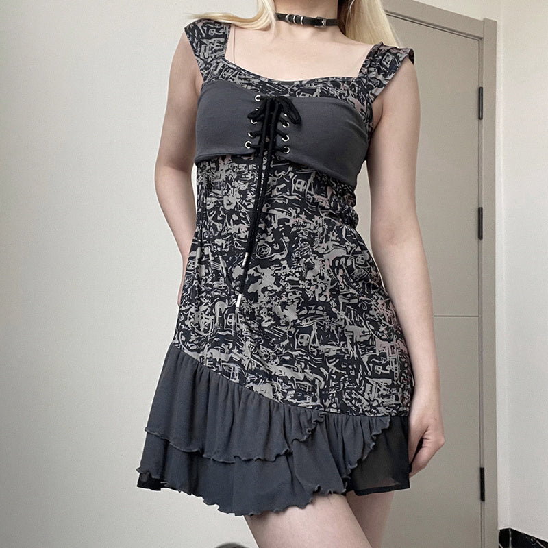 Person wearing a black and gray patterned dress with a plain background