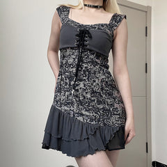 Person wearing a black and gray patterned dress with a plain background